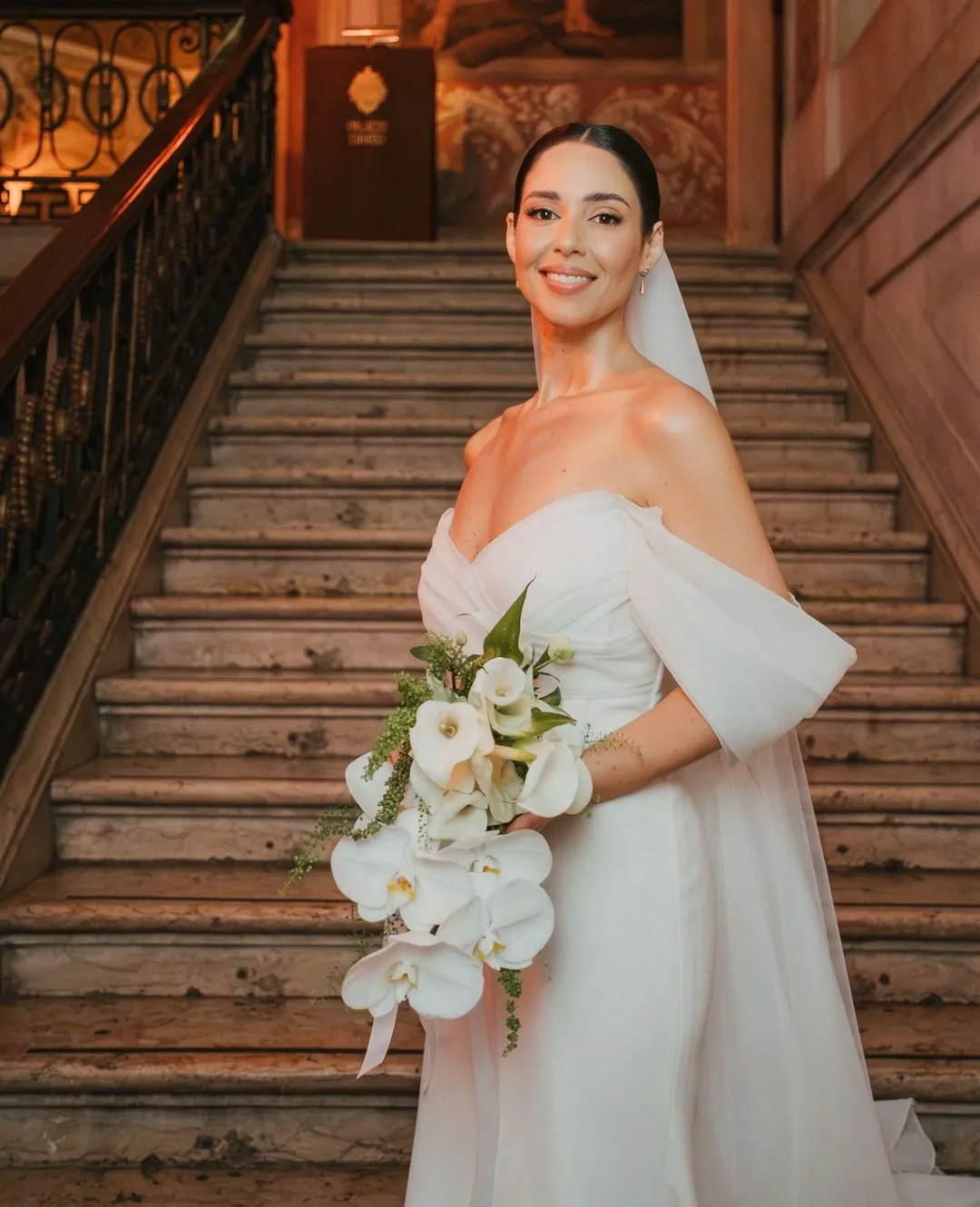 Noiva em escadaria de palácio em Lisboa com bouquet de orquídeas